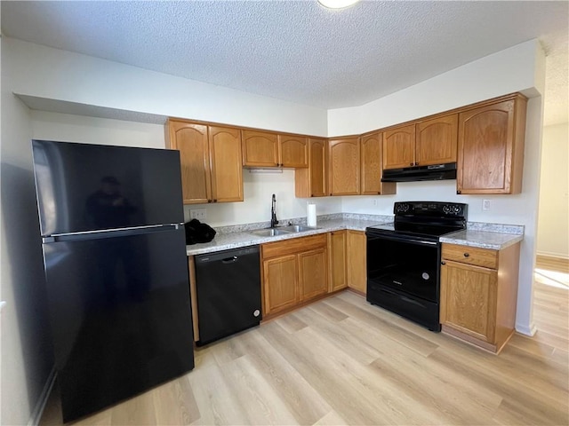 10818-10820 W 57th St, Shawnee, KS 66203 - kitchen with black appliances, under cabinet range hood, light countertops, light wood-style floors, and a textured ceiling
