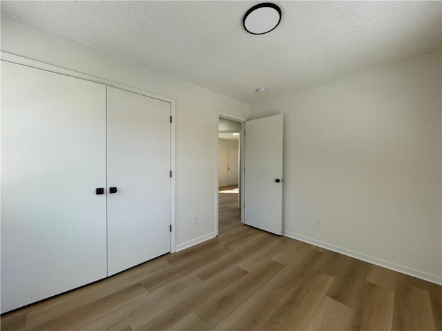 10818-10820 W 57th St, Shawnee, KS 66203 - unfurnished bedroom with wood finished floors, a closet, and a textured ceiling