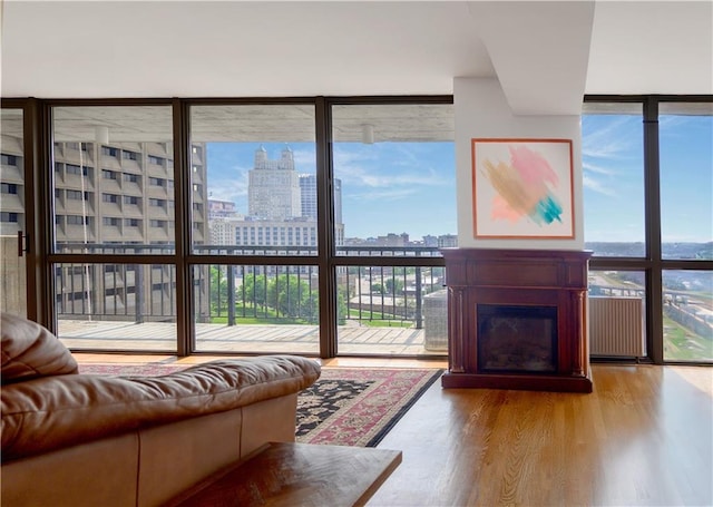600 Admiral Blvd Unit 1505, Kansas City, MO 64106 - living room featuring floor to ceiling windows, a view of skyline, wood finished floors, healthy amount of natural light, and a glass covered fireplace
