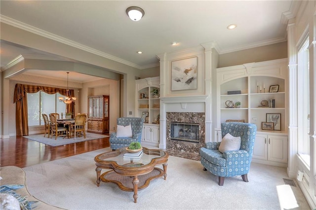 16042 Overbrook Ln, Stilwell, KS 66085 - living room featuring a chandelier, plenty of natural light, a premium fireplace, ornamental molding, and light wood-style floors
