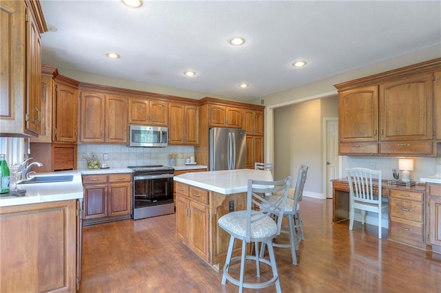 16042 Overbrook Ln, Stilwell, KS 66085 - kitchen featuring stainless steel appliances, brown cabinets, a breakfast bar area, a center island, and recessed lighting