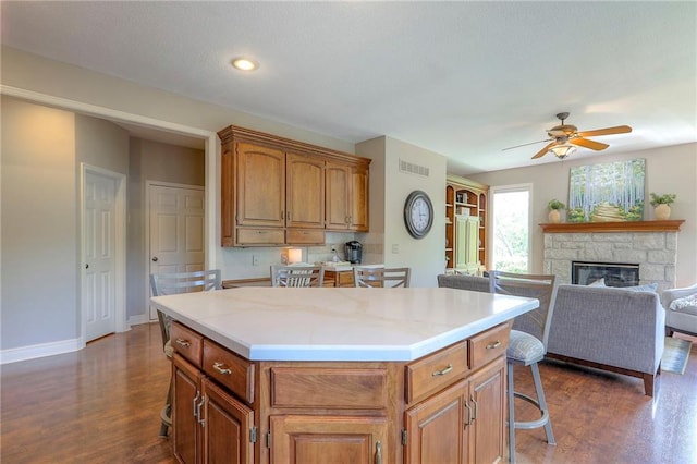 16042 Overbrook Ln, Stilwell, KS 66085 - kitchen featuring a kitchen bar, dark wood-style flooring, a center island, ceiling fan, and recessed lighting