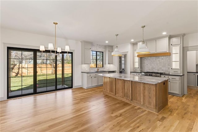 6000 El Monte St, Fairway, KS 66205 - kitchen featuring backsplash, light wood-type flooring, recessed lighting, stove, and light stone countertops