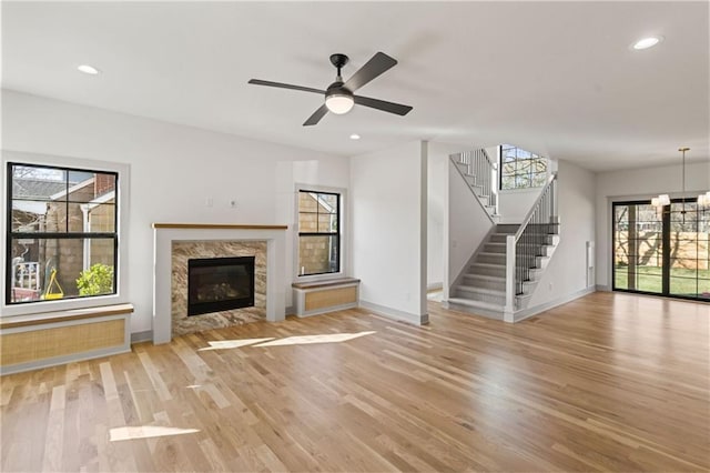 6000 El Monte St, Fairway, KS 66205 - unfurnished living room featuring light wood finished floors, a fireplace, stairs, a ceiling fan, and recessed lighting
