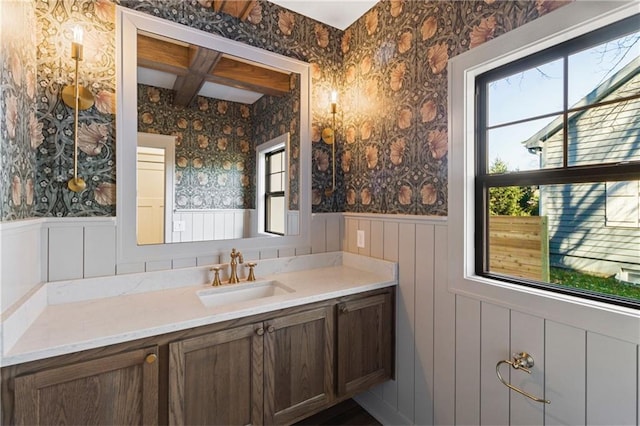 6000 El Monte St, Fairway, KS 66205 - bathroom featuring wallpapered walls, wainscoting, vanity, beam ceiling, and coffered ceiling