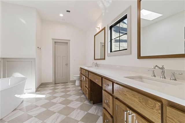 6000 El Monte St, Fairway, KS 66205 - bathroom with a skylight, a freestanding tub, double vanity, tile patterned floors, and lofted ceiling