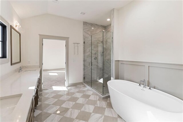 6000 El Monte St, Fairway, KS 66205 - full bath with a freestanding bath, double vanity, a marble finish shower, vaulted ceiling, and a decorative wall