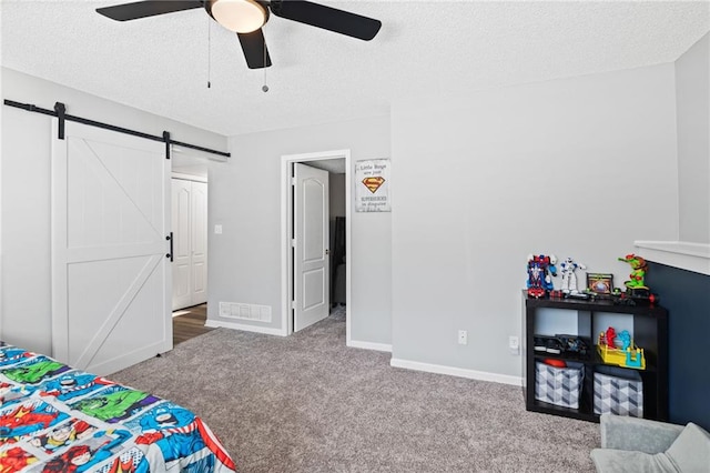 4416 Broadway Ter, Leavenworth, KS 66048 - bedroom featuring a barn door, carpet flooring, a textured ceiling, and a ceiling fan
