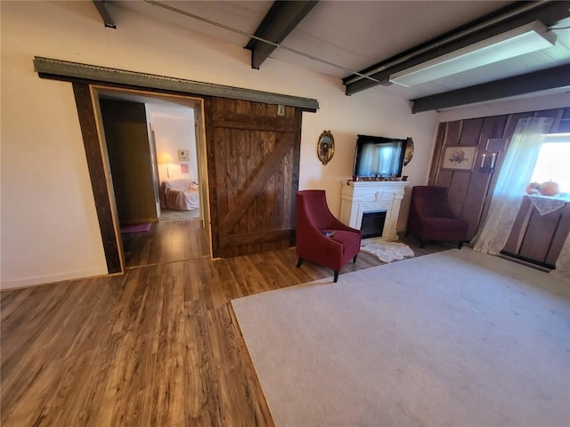 204 E Casey Rd, Lone Jack, MO 64070 - sitting room with wood finished floors, beam ceiling, and a glass covered fireplace