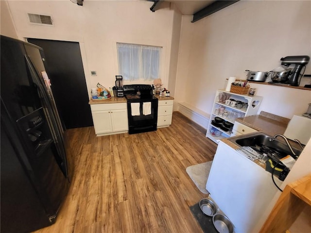 204 E Casey Rd, Lone Jack, MO 64070 - kitchen featuring black appliances, light wood-type flooring, and white cabinets