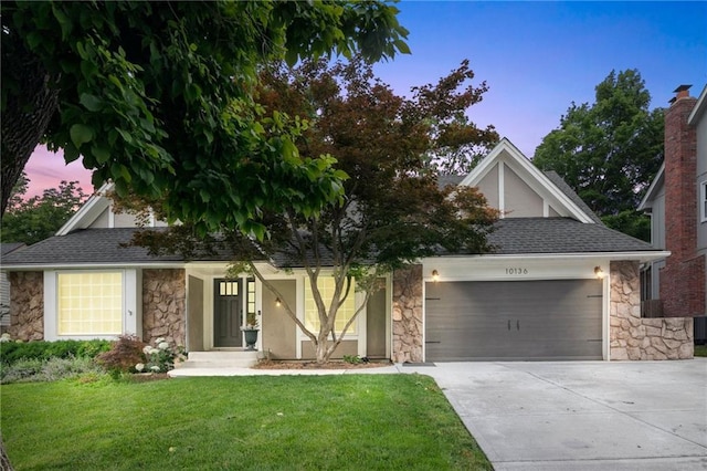 10136 Barton St, Overland Park, KS 66214 - view of front of house with stone siding, a garage, driveway, and a front yard