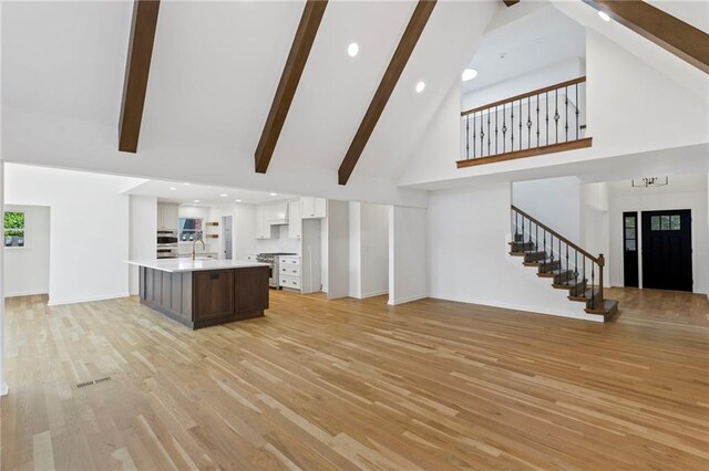 10136 Barton St, Overland Park, KS 66214 - unfurnished living room with high vaulted ceiling, stairs, light wood finished floors, beam ceiling, and recessed lighting