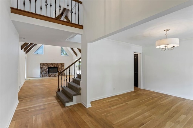 10136 Barton St, Overland Park, KS 66214 - stairway with wood finished floors, a high ceiling, a fireplace, and a chandelier