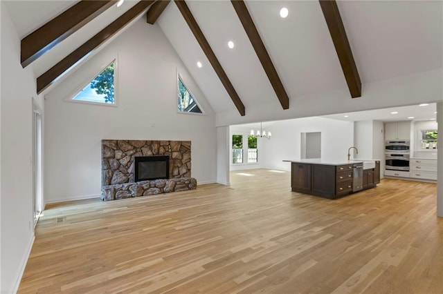 10136 Barton St, Overland Park, KS 66214 - unfurnished living room featuring high vaulted ceiling, a chandelier, beamed ceiling, light wood finished floors, and a fireplace