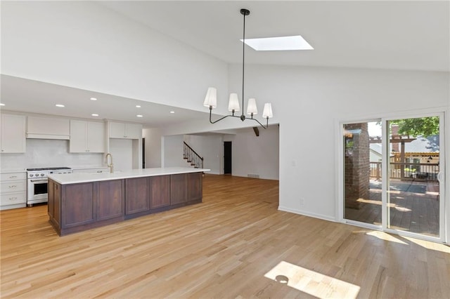 10136 Barton St, Overland Park, KS 66214 - kitchen with high end range, open floor plan, high vaulted ceiling, a skylight, and light countertops