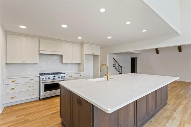 10136 Barton St, Overland Park, KS 66214 - kitchen featuring stainless steel range, white cabinetry, light wood-style flooring, decorative backsplash, and recessed lighting