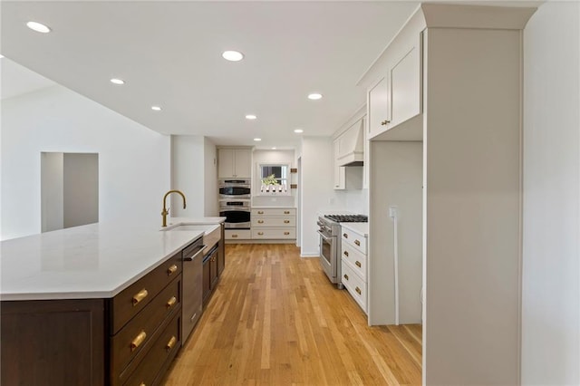 10136 Barton St, Overland Park, KS 66214 - kitchen featuring appliances with stainless steel finishes, white cabinetry, light countertops, dark brown cabinetry, and recessed lighting