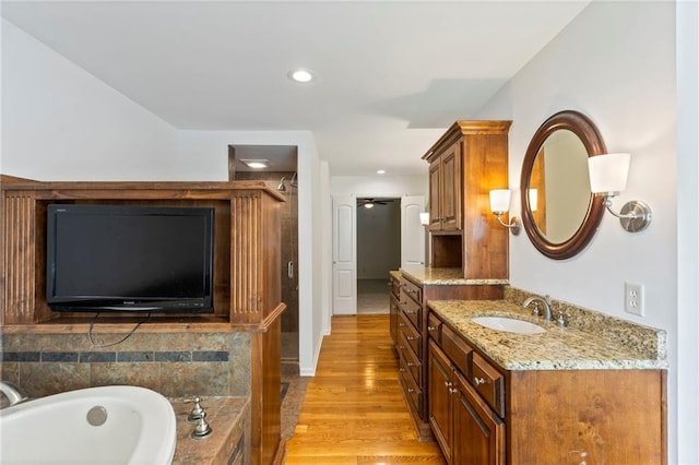 10136 Barton St, Overland Park, KS 66214 - full bath with vanity, wood finished floors, a garden tub, a shower, and recessed lighting