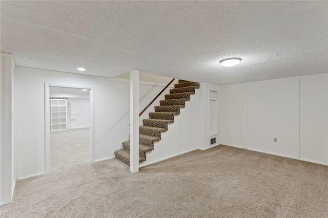 10136 Barton St, Overland Park, KS 66214 - finished basement with stairs, carpet floors, and a textured ceiling