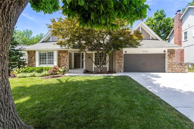 10136 Barton St, Overland Park, KS 66214 - view of property hidden behind natural elements featuring stone siding, an attached garage, a front lawn, and concrete driveway