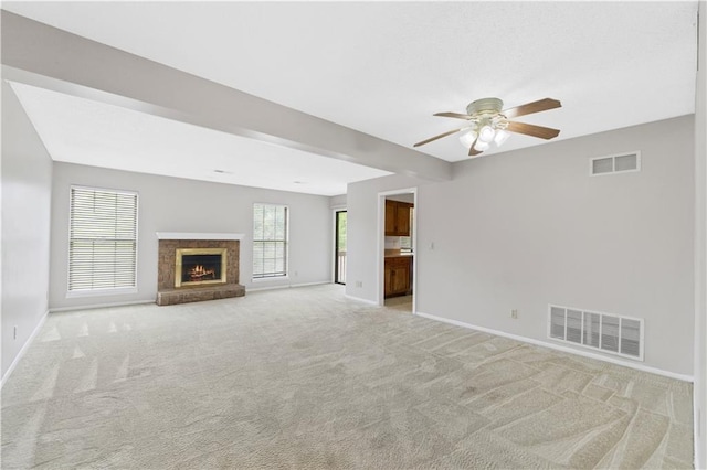 12740 W 110th Ter, Overland Park, KS 66210 - unfurnished living room featuring light carpet, a ceiling fan, and a warm lit fireplace