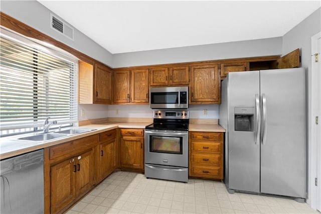 12740 W 110th Ter, Overland Park, KS 66210 - kitchen with stainless steel appliances, brown cabinets, light countertops, and light floors