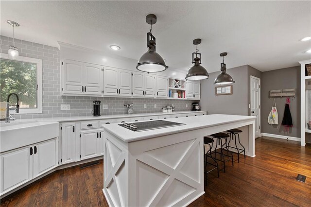 414 N 4th St, Gower, MO 64454 - kitchen with black electric cooktop, tasteful backsplash, white cabinetry, light countertops, and dark wood finished floors