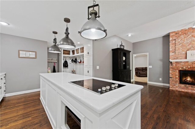 414 N 4th St, Gower, MO 64454 - kitchen featuring black electric cooktop, white cabinetry, a fireplace, dark wood-style flooring, and recessed lighting
