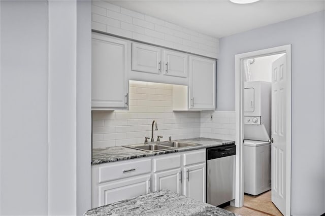 4143 Roanoke Rd Unit 10, Kansas City, MO 64111 - kitchen featuring stainless steel dishwasher, estacked washer and dryer, and white cabinetry
