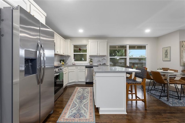 1304 Nashua Rd, Liberty, MO 64068 - kitchen with stainless steel appliances, a kitchen bar, decorative backsplash, white cabinetry, and a center island