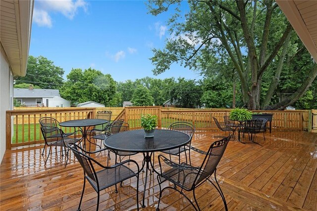 1304 Nashua Rd, Liberty, MO 64068 - wooden terrace featuring outdoor dining area and view of scattered trees