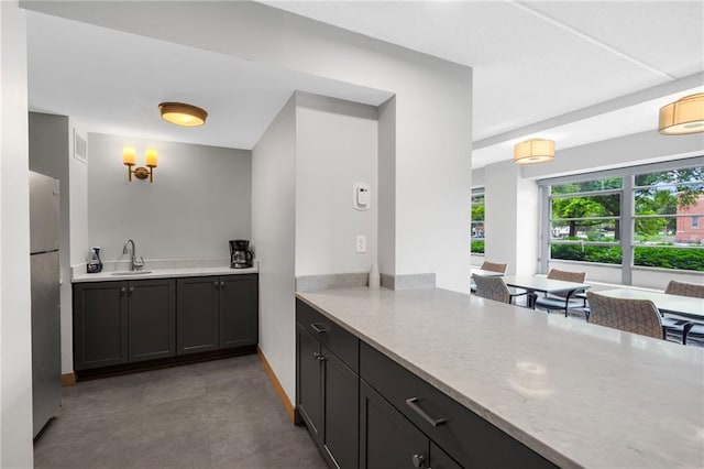 333 W Meyer Blvd # 212, Kansas City, MO 64113 - kitchen featuring freestanding refrigerator and light stone counters