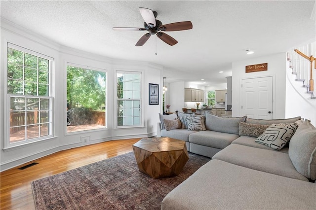 14712 Woodward St, Overland Park, KS 66223 - living room with stairway, wood finished floors, ceiling fan, recessed lighting, and crown molding