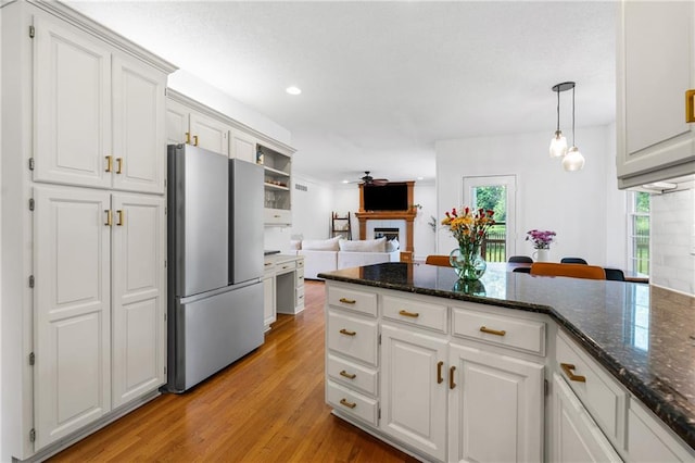 14712 Woodward St, Overland Park, KS 66223 - kitchen with freestanding refrigerator, light wood-style floors, white cabinetry, a fireplace, and recessed lighting