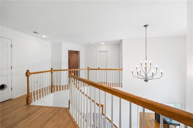 14712 Woodward St, Overland Park, KS 66223 - hall with an upstairs landing, wood finished floors, a chandelier, and recessed lighting
