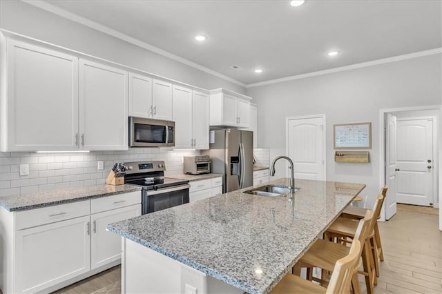 21404 W 47th Ter, Shawnee, KS 66218 - kitchen with stainless steel appliances, a kitchen breakfast bar, white cabinetry, tasteful backsplash, and an island with sink