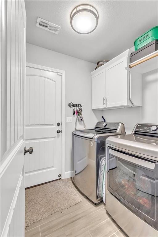 21404 W 47th Ter, Shawnee, KS 66218 - washroom with cabinet space, separate washer and dryer, and light wood-style flooring