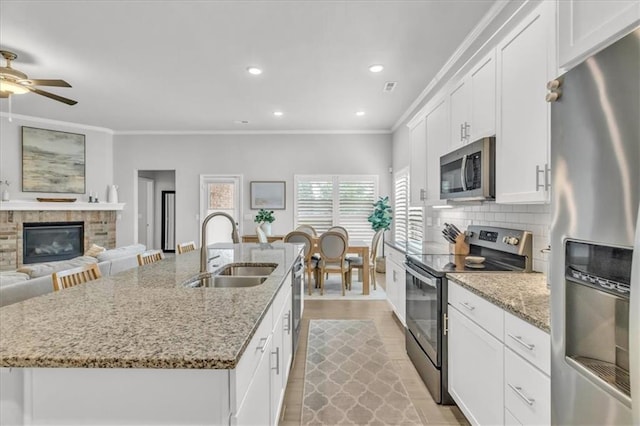 21404 W 47th Ter, Shawnee, KS 66218 - kitchen featuring stainless steel appliances, ornamental molding, an island with sink, a ceiling fan, and white cabinets