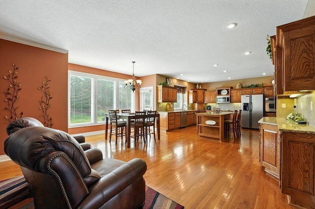 2312 NE Sweet Water Dr, Lees Summit, MO 64086 - living area with a chandelier, light wood finished floors, a textured ceiling, and recessed lighting