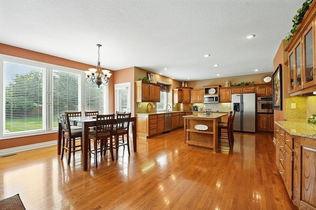 2312 NE Sweet Water Dr, Lees Summit, MO 64086 - dining space featuring a chandelier, light wood-type flooring, recessed lighting, and a textured ceiling