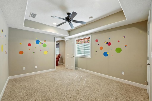 2312 NE Sweet Water Dr, Lees Summit, MO 64086 - unfurnished bedroom featuring a tray ceiling, light carpet, and ceiling fan