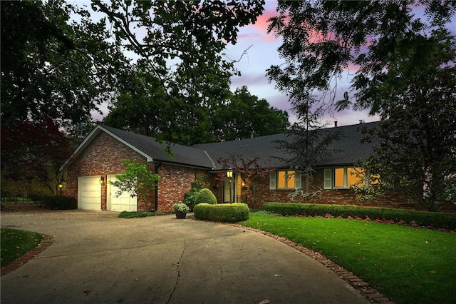 490 W 49th Ter, Kansas City, MO 64112 - ranch-style house with concrete driveway, brick siding, an attached garage, and a lawn