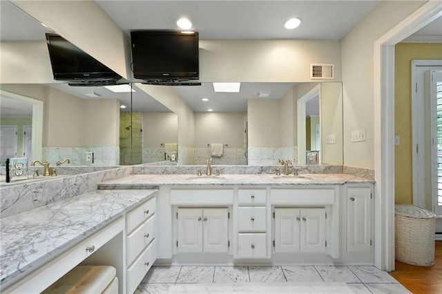 490 W 49th Ter, Kansas City, MO 64112 - bathroom featuring double vanity, healthy amount of natural light, recessed lighting, and a shower