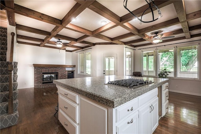 26528-23.09 S Metcalf Rd, Louisburg, KS 66053 - kitchen featuring a ceiling fan, stainless steel gas cooktop, coffered ceiling, dark wood-type flooring, and a brick fireplace