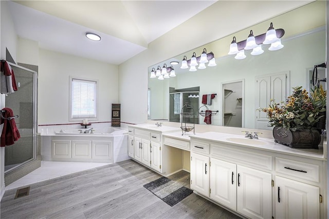 26528-23.09 S Metcalf Rd, Louisburg, KS 66053 - full bath with a shower stall, double vanity, a garden tub, and wood finished floors