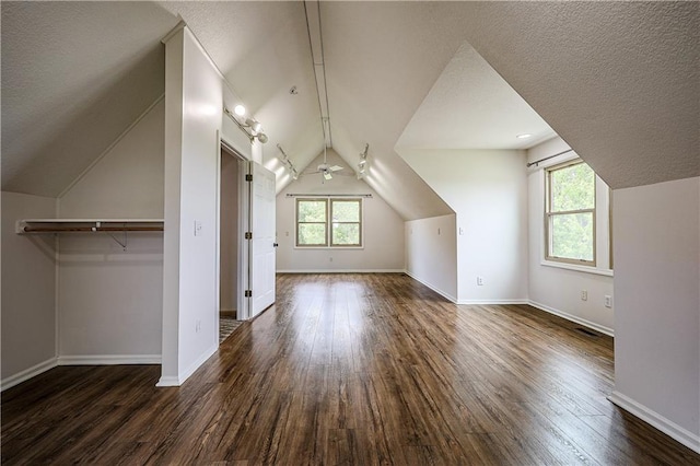 26528-23.09 S Metcalf Rd, Louisburg, KS 66053 - additional living space featuring lofted ceiling, healthy amount of natural light, dark wood-style flooring, ceiling fan, and a textured ceiling