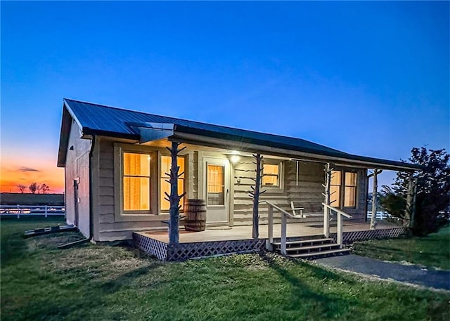 26528-23.09 S Metcalf Rd, Louisburg, KS 66053 - view of front of house featuring covered porch, a lawn, and a metal roof