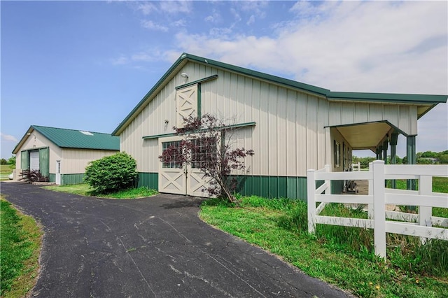 26528-23.09 S Metcalf Rd, Louisburg, KS 66053 - view of front of property featuring a detached garage, an outbuilding, and board and batten siding