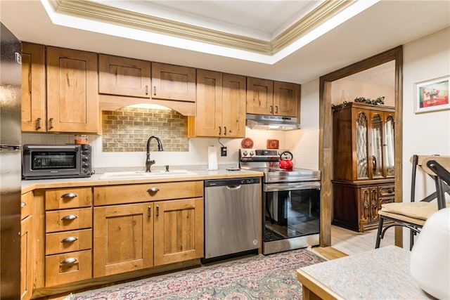10902 W 96th Ter, Overland Park, KS 66214 - kitchen with appliances with stainless steel finishes, under cabinet range hood, light countertops, light wood-style floors, and a tray ceiling