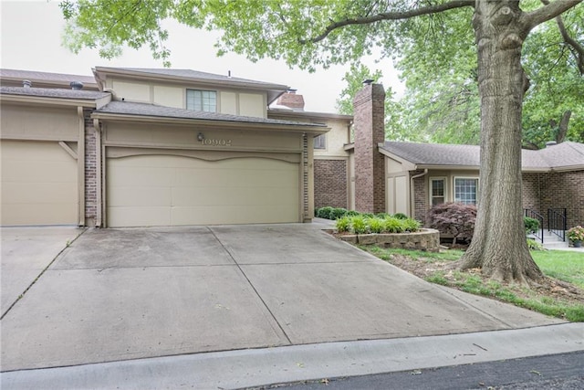 10902 W 96th Ter, Overland Park, KS 66214 - view of front facade featuring concrete driveway, a garage, a chimney, and brick siding
